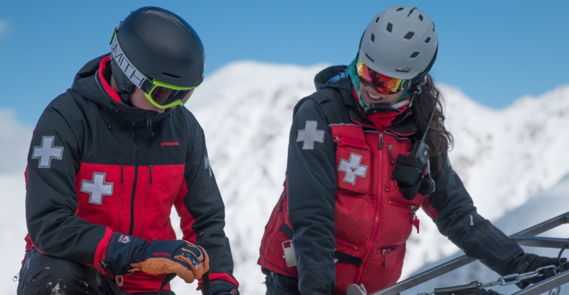 patrollers on ski hill smiling